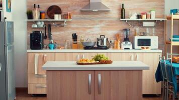 clásico moderno cocina con mesa en el medio de él, bonito de madera detalles y parquet piso. cena habitación, abierto espacio, diseño lujo arquitectura residencial decoración con comida mesa en el medio de el habitación. video