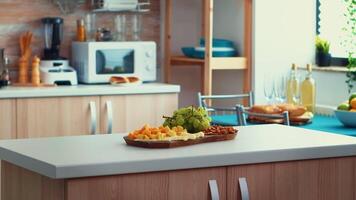 Close up of kitchen table with cheese and grapes on it. Open space room interior with daylight, design luxury arhitecture residential decoration with dining table in the middle of the room. video