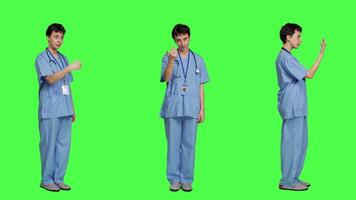 Medical assistant asking a person to come over closer against greenscreen backdrop, inviting patient to approach. Nurse in scrubs calling someone at checkup examination, young surgeon. Camera A. video