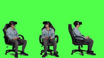 Cheerful player winning online shooter championship against greenscreen backdrop, celebrating her victory. Woman playing gaming tournament with virtual reality headset and controller. Camera A. video