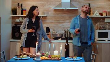 Caucasian young adults fighting during romantic dinner. Frustrated people with couple problems having conflicts at home, in the kitchen, drinking red wine, talking, after eating meal in dining room video