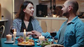 Handsome young man asking for marriage his girlfriend. Man making proposal to his bride fiancee to be in the kitchen during romantic dinner. Happy surprised woman smiling being speechless. video