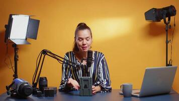 Influencer talking about professional video equipment in her studio set. Professional videography gear review by content creator new media star influencer on social media.