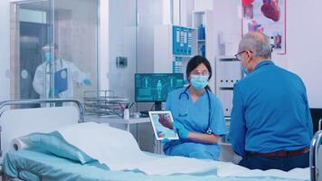 hjärt- patient få förklaring från sjuksköterska bär en mask i modern privat sjukhus klinik. engelska sjukan, osteomalaci osteogenes imperfecta eller marmor ben sjukdom samråd under coronavirus video