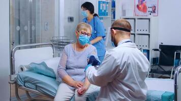 Doctor in protective wear checking hypertension patient in modern private hospital or clinic during COVID-19 pandemic. Health care check, medical medicine illness examination diagnostic video