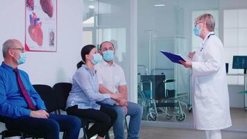 défavorable nouvelles de médecin à Jeune couple dans hôpital attendre zone pendant couronne virus épidémie. mari et épouse portant visage masque contre infection avec convoitise 19. video