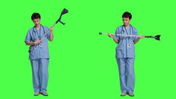 Hospital staff worker assembling crutches to help with mobility and healing, preparing walking tool for someone with broken leg. Medical assistant helping patient with fracture. Camera A. video