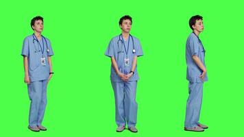 Stressed nurse checking time on watch and waiting for patient to arrive at checkup examination, being impatient against greenscreen backdrop. Medical assistant with scrubs and stethoscope. Camera A. video