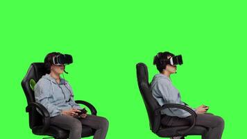 Cheerful player winning online shooter championship against greenscreen backdrop, celebrating her victory. Woman playing gaming tournament with virtual reality headset and controller. Camera B. video