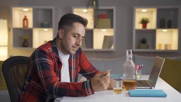 Thoughtful man with wedding ring in hand drinking alcohol. video