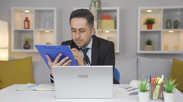 Home office worker man examining, analyzing documents. video