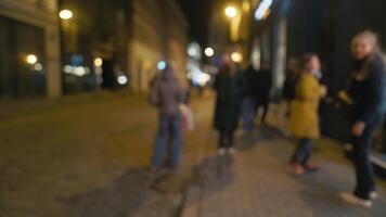 Blurry image of pedestrians on city sidewalk at night video