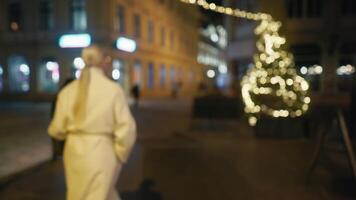 een vrouw wandelen Bij middernacht in de stad met een Kerstmis boom in de achtergrond video