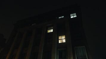 Tower block gleams with tinted windows' glow at midnight video