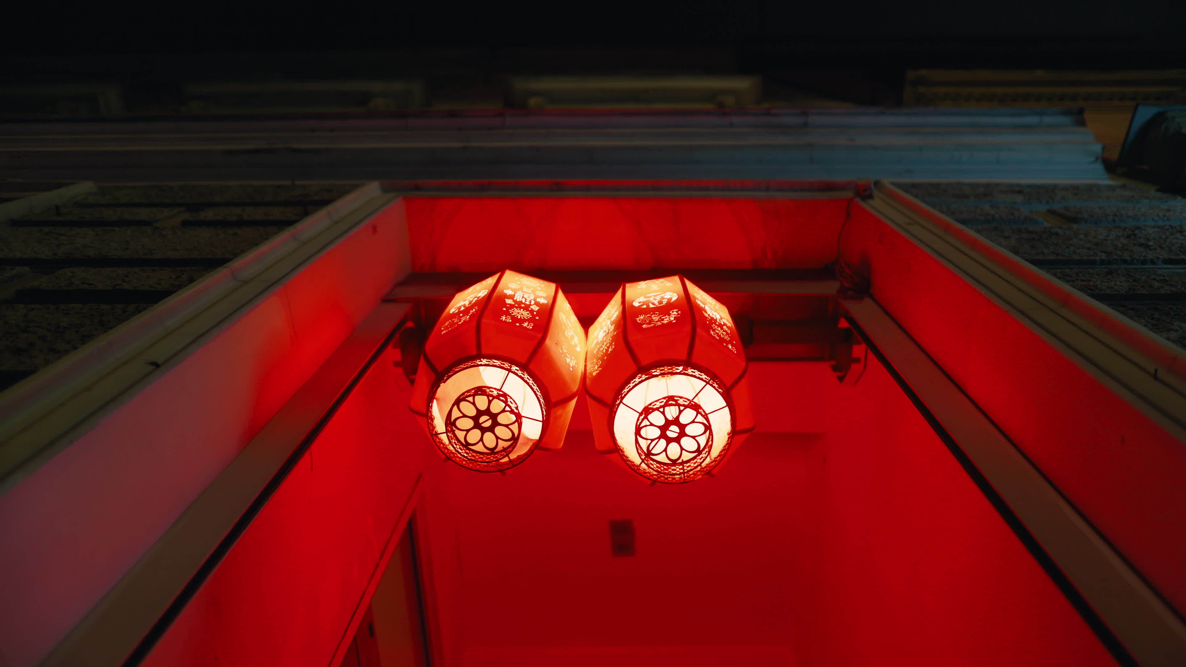 Lanternlit symmetry. Two red lanterns hang symmetrically, casting a