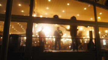 A blurry image of people in front of a window at an evening event video