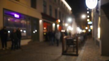 een middernacht tafereel van stad straat met wazig figuren wandelen door gebouwen video