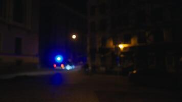 A police car with electric blue lights driving on a dark city road at midnight video