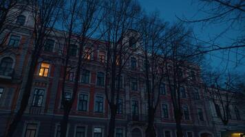 Historic building at night behind bare trees in Spring video