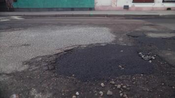 schließen oben von Schlagloch im Straße Oberfläche, umgeben durch Gras video