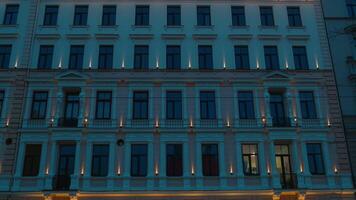 Urban design tower block with azure tinted windows illuminates the night video