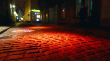 Brick road with amber Automotive lighting on cobblestone street at night video