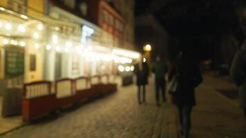 Blurry image of pedestrians on city street at midnight video