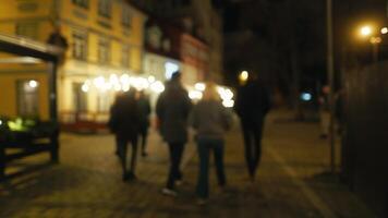 Pedestrians walking on the city street, navigating the darkness at midnight video