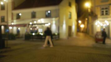 A fuzzy image of a couple strolling on a nighttime street between buildings video