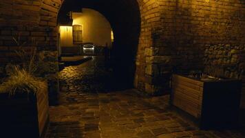 Dark hallway with brick wall arch doorway at night in building video