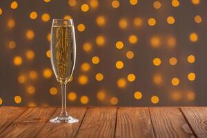 Glasses with champagne on a wooden background against a bokeh background of lights photo