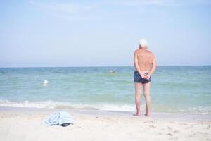 Alone unrecognizable senior man standing sea beach Sadness loneliness ageing solitude aged photo