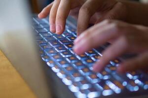 Close up image of hands typing on laptop computer keyboard and surfing the internet at home. Freelancer copywriter working project, typing text, edit something. Remote job concept photo