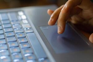 Close up image of hands typing on laptop computer keyboard and surfing the internet at home. Freelancer copywriter working project, typing text, edit something. Remote job concept photo