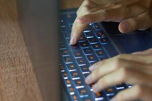 Close up image of hands typing on laptop computer keyboard and surfing the internet at home. Freelancer copywriter working project, typing text, edit something. Remote job concept photo