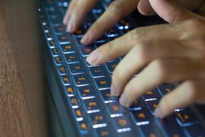 Close up image of hands typing on laptop computer keyboard and surfing the internet at home. Freelancer copywriter working project, typing text, edit something. Remote job concept photo