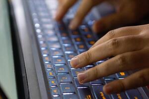 Close up image of hands typing on laptop computer keyboard and surfing the internet at home. Freelancer copywriter working project, typing text, edit something. Remote job concept photo