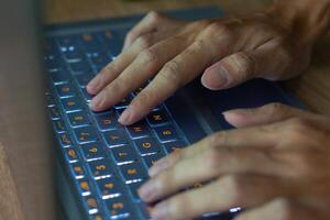 Close up image of hands typing on laptop computer keyboard and surfing the internet at home. Freelancer copywriter working project, typing text, edit something. Remote job concept photo