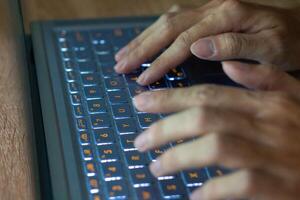 Close up image of hands typing on laptop computer keyboard and surfing the internet at home. Freelancer copywriter working project, typing text, edit something. Remote job concept photo