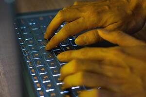 Close up image of hands typing on laptop computer keyboard and surfing the internet at home. Freelancer copywriter working project, typing text, edit something. Remote job concept photo
