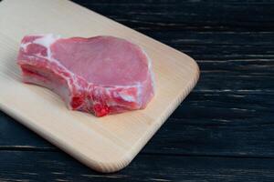 Top view of one pieces raw pork chop steaks on a cutting board. photo