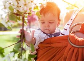 Unrecognizable young mother with her infant baby in sling photo