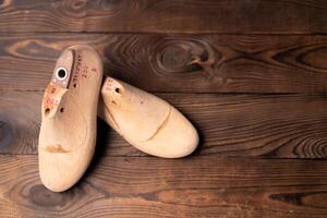 Leather samples for shoes and wooden shoe last on blue wooden table. photo