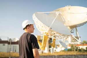 Engineer looking earth based astronomical radio telescope photo