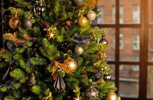 Close-up of a Christmas tree decorated with gold balls and blue bows. Christmas holiday concept photo