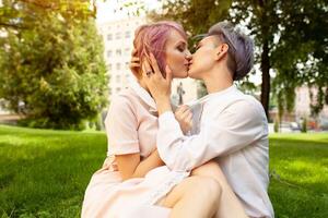 Happy playful lesbian couple in love sharing time together Women friendship concept with girls couple having fun on fashion clothes outdoors Summertime leisure. photo