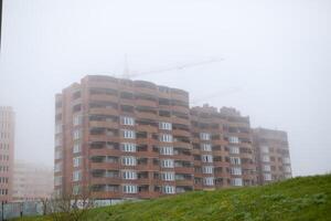 construcción edificio grúas en niebla foto