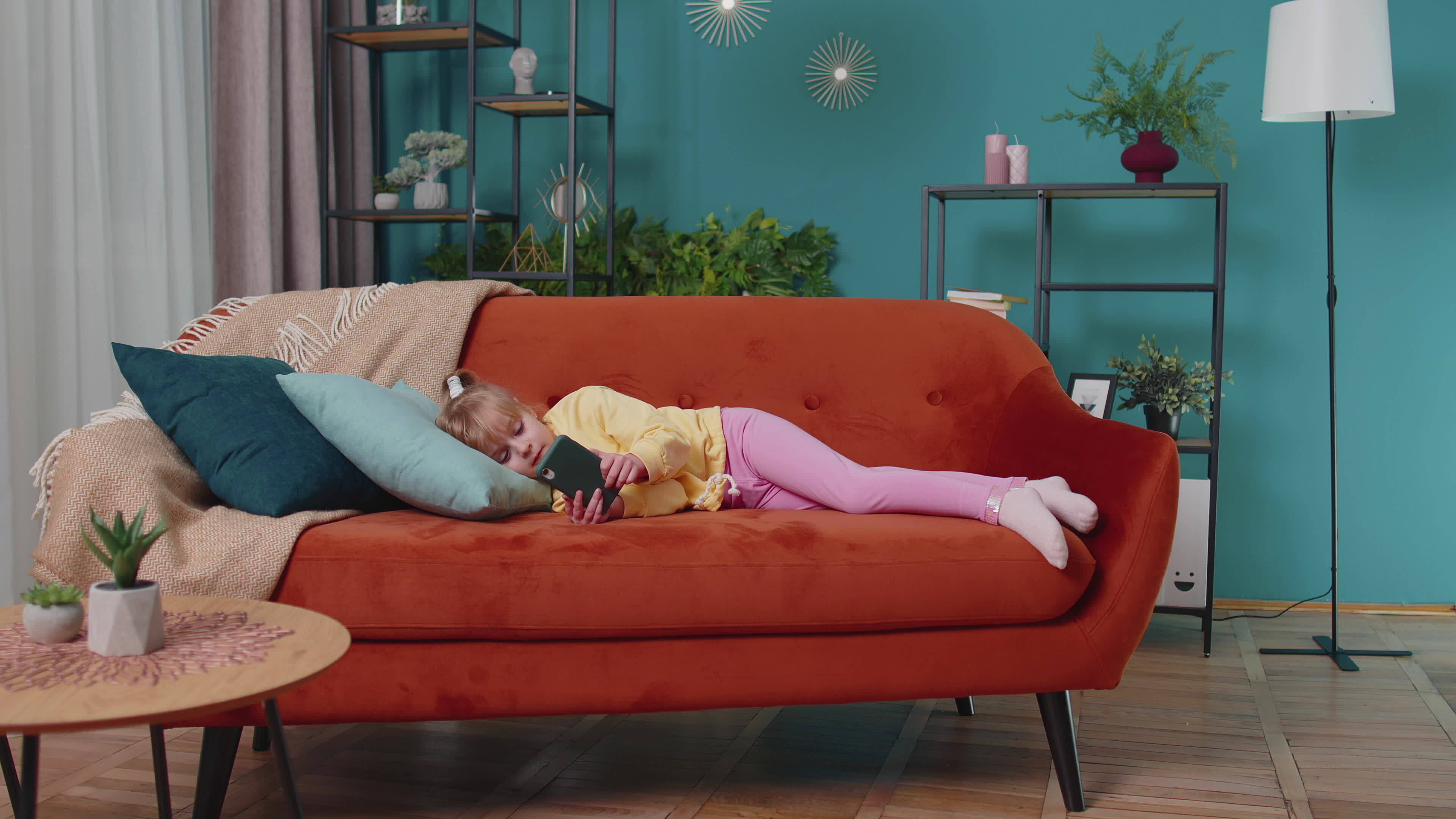 Child toddler hold smartphone watching online cartoons, chatting with friends on sofa alone at home 41481848 Stock Video at Vecteezy