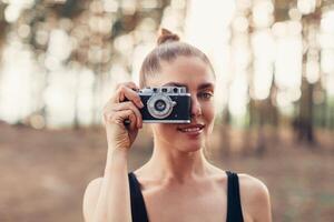 Hipster girl with using vintage photo camera close up, copy space of blank empty mockup, view tourist holding in hands and photograph on device travel on background