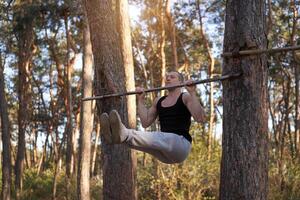 Handsome caucasian men pull-up outdoor workout cross training morning Pumping up arm exercising sports ground nature forest photo